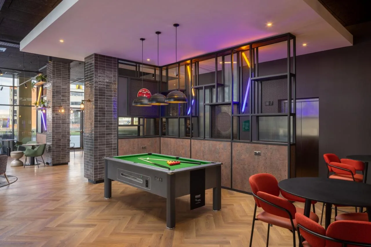 a room with a pool table and some chairs at Aloft by Marriott Belfast Titanic Quarter in Belfast